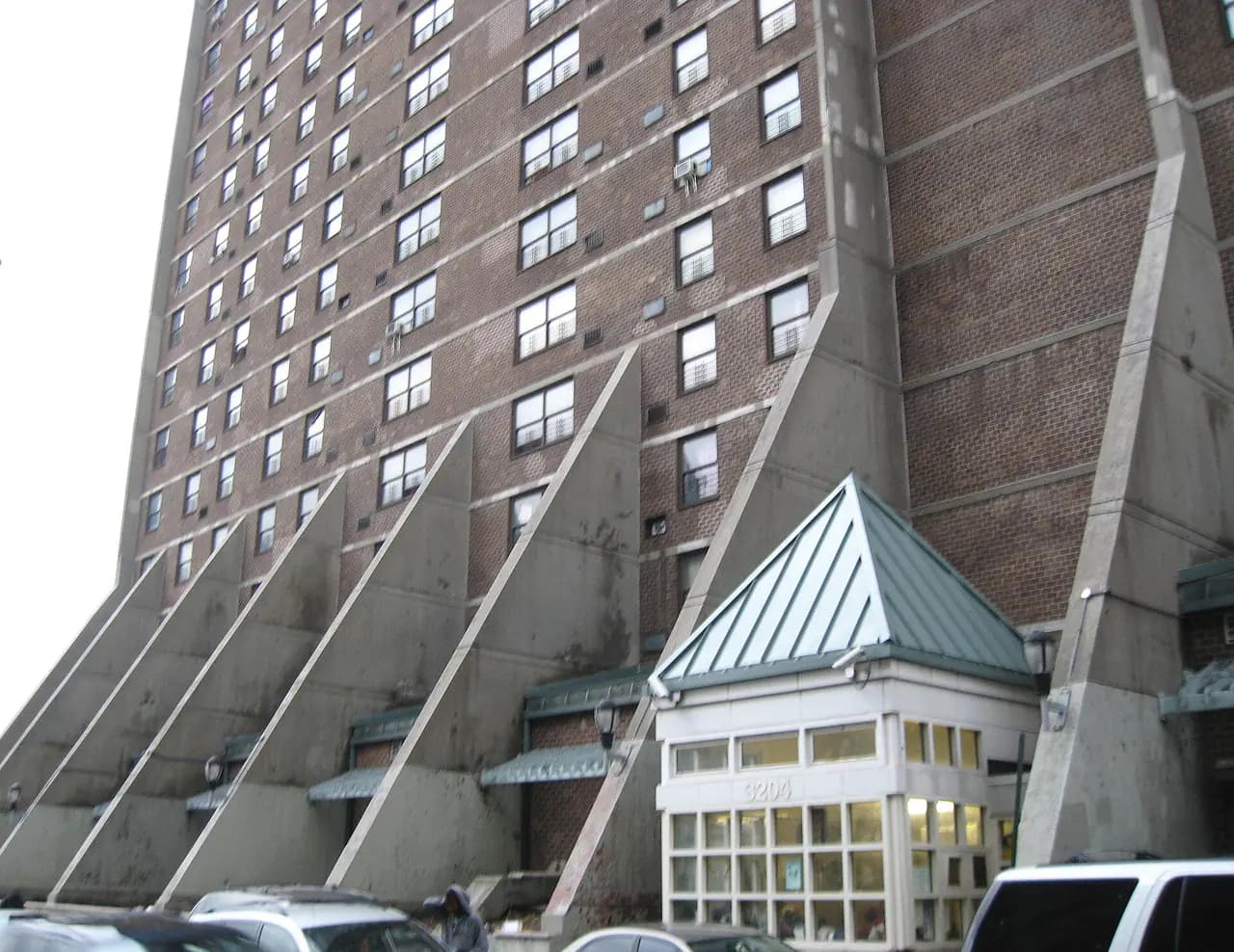 Brick NYCHA tower with angled concrete buttresses at Morrisania Air Rights, seen from Park Avenue