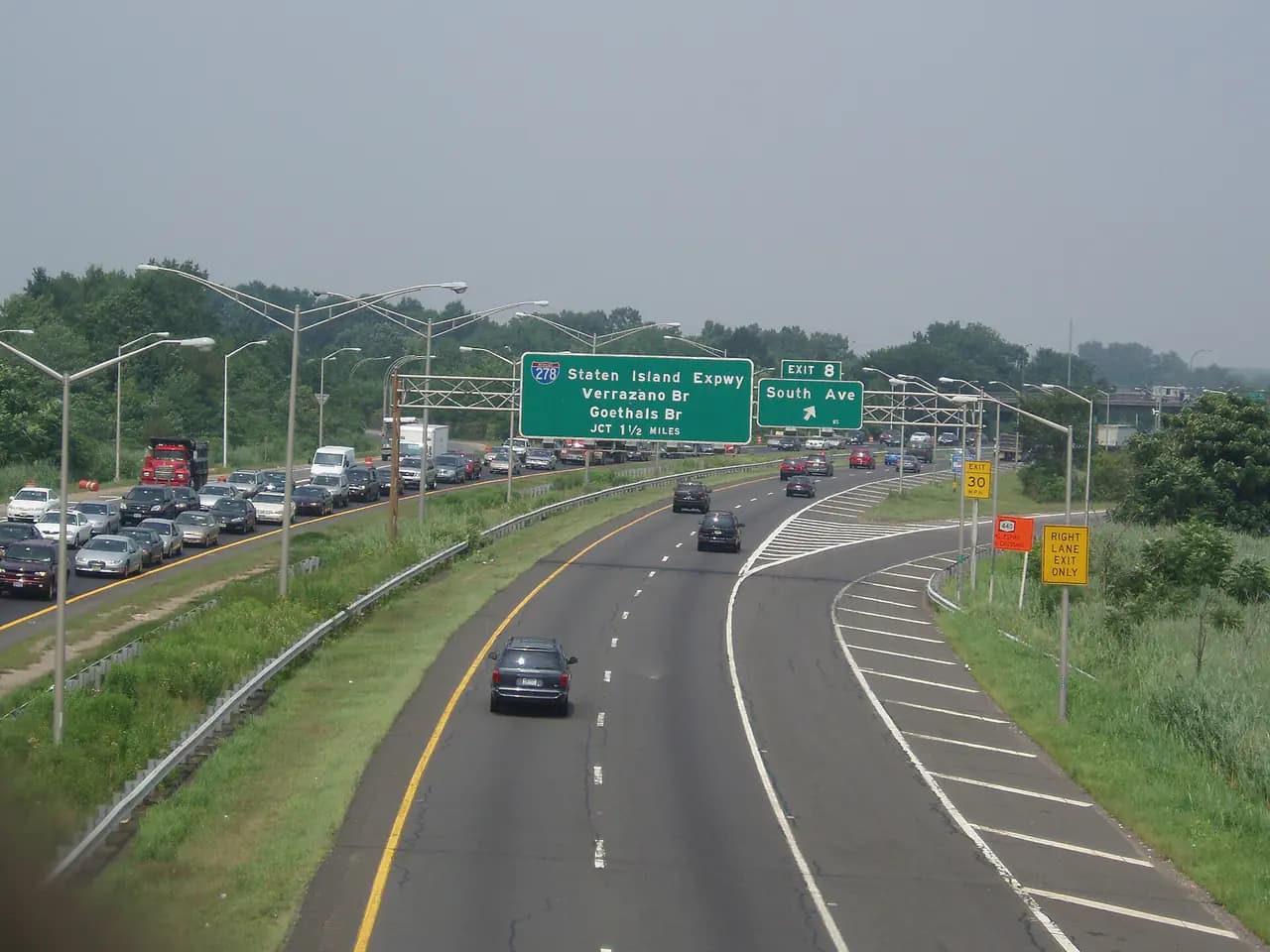 The West Shore Expressway on Staten Island seen from an overpass, with green highway signs for the Staten Island Expressway and Exit 8