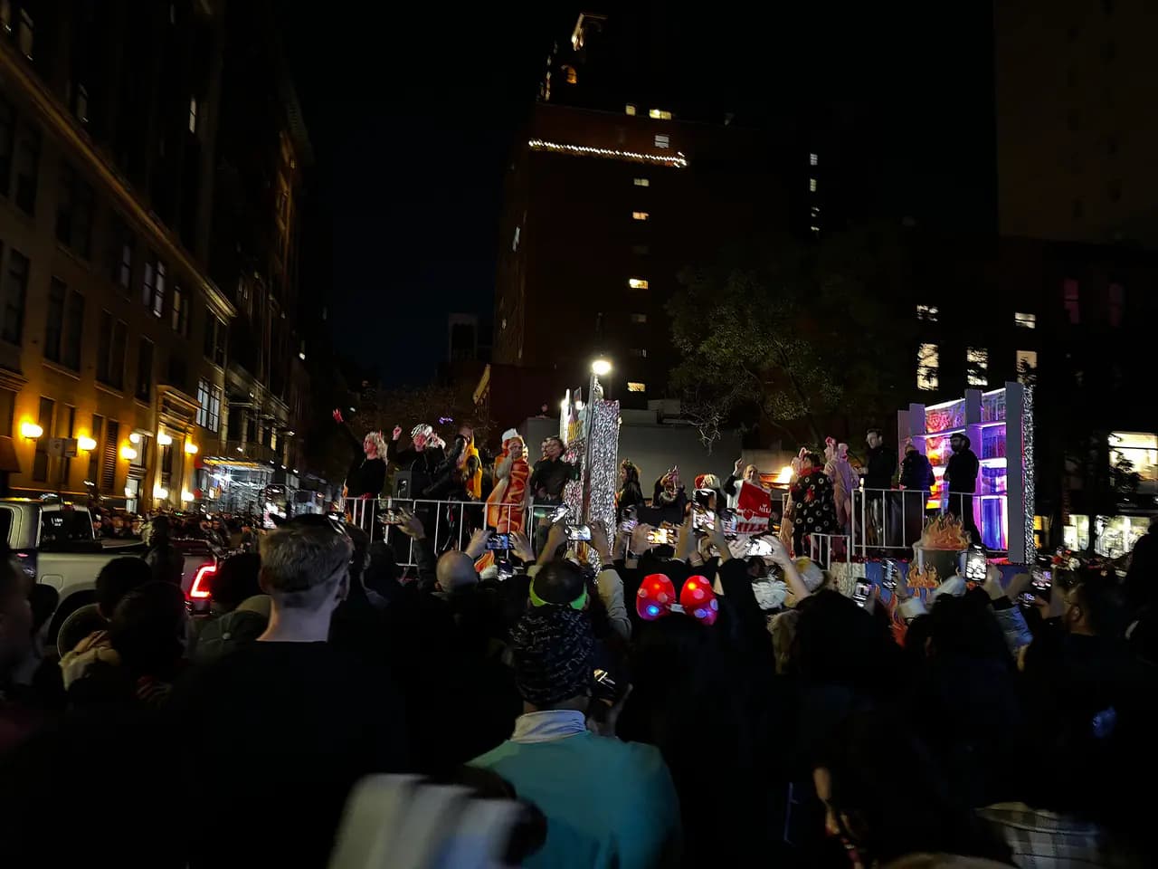Crowds in costume along Sixth Avenue at night during the Village Halloween Parade in Manhattan
